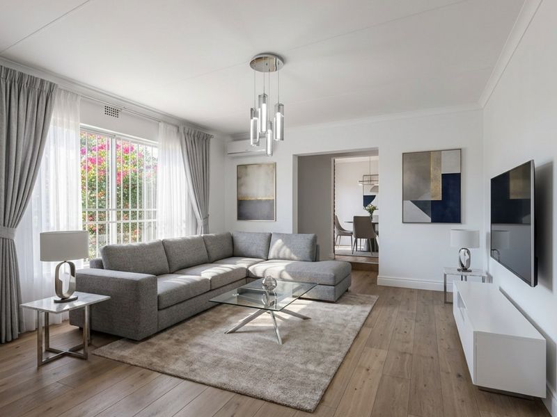 A bright and modern living room featuring laminate flooring, a wall-mounted air conditioning unit, and large windows allowing for natural light.