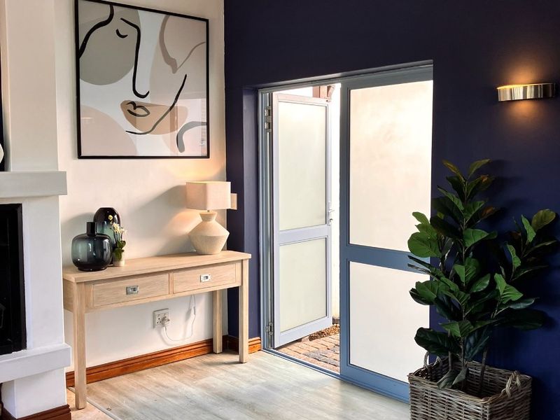 A well-maintained living area featuring a fireplace, modern laminate flooring, and a glass door providing access to the exterior.