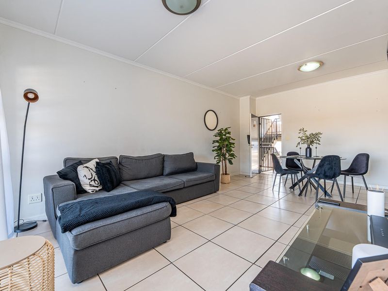 Open plan living and dining area featuring neutral tiled flooring and direct access to the entrance.