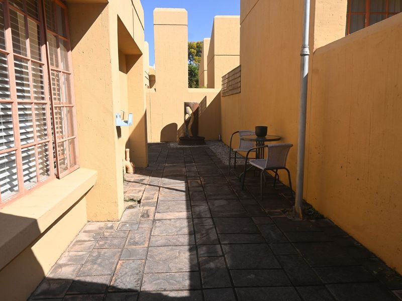 A private paved courtyard area featuring a decorative water feature and high perimeter walls, providing a secluded outdoor space.