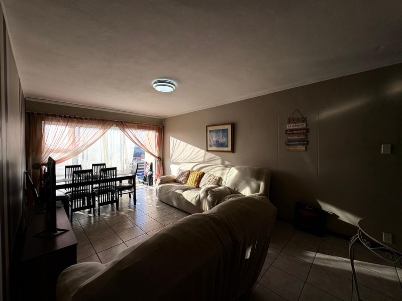Open plan living and dining area featuring tiled flooring and a large sliding glass door providing natural light.