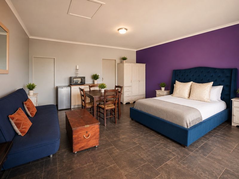 Spacious bedroom featuring tiled flooring, a built-in cupboard, and a loft access hatch, offering a versatile layout with integrated living and dining space.