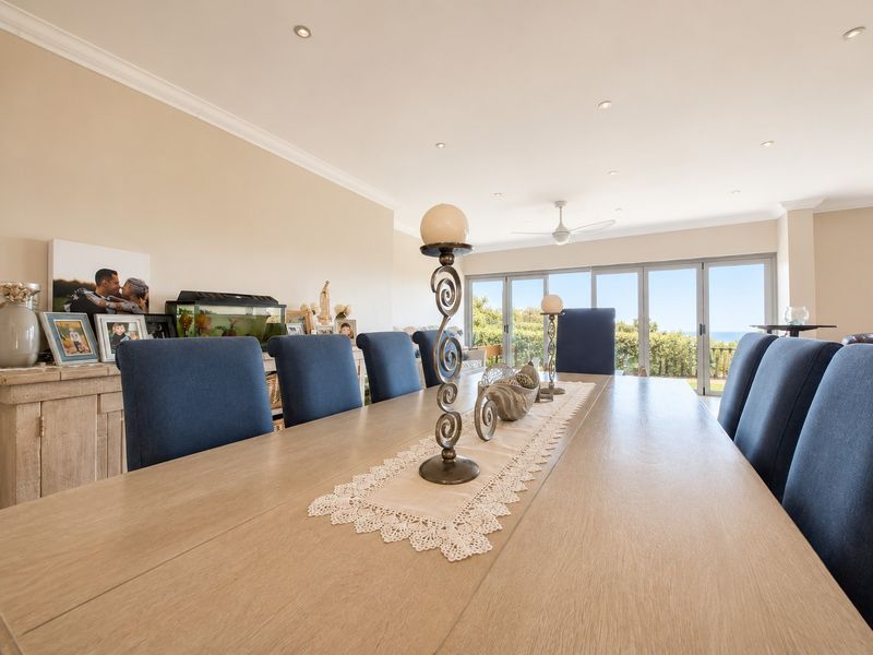 Spacious dining area featuring recessed lighting, ceiling fan, and large aluminium stacking doors that provide natural light and access to the outdoor area.
