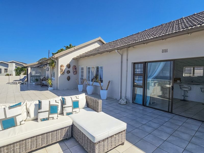 Spacious tiled patio area featuring large sliding glass doors providing seamless indoor-outdoor flow, ideal for entertaining.