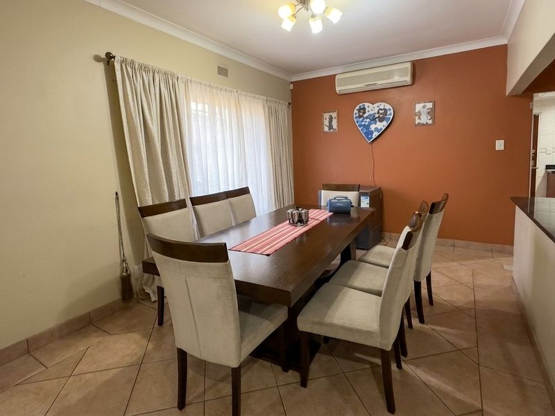 A dining room featuring tiled flooring, a split-system air conditioner, and access to the outdoors via a sliding glass door.