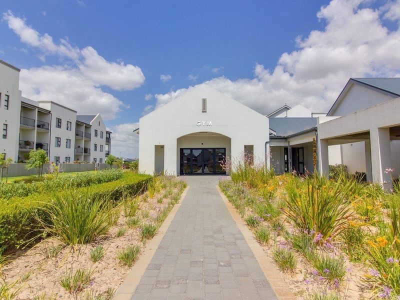 Exterior view of the retirement village gym facility, featuring a paved walkway, landscaped gardens, and a modern entrance.
