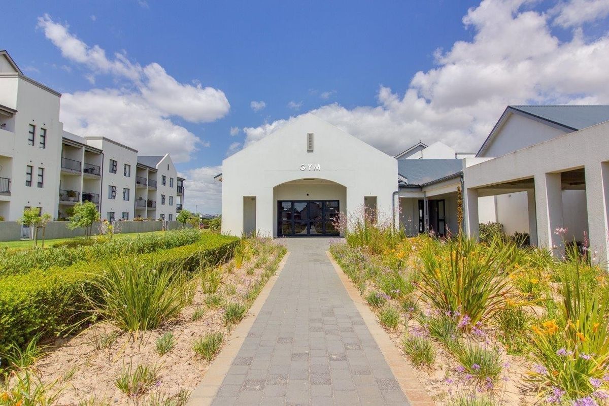 Exterior view of the retirement village gym facility, featuring a paved walkway, landscaped gardens, and a modern entrance.