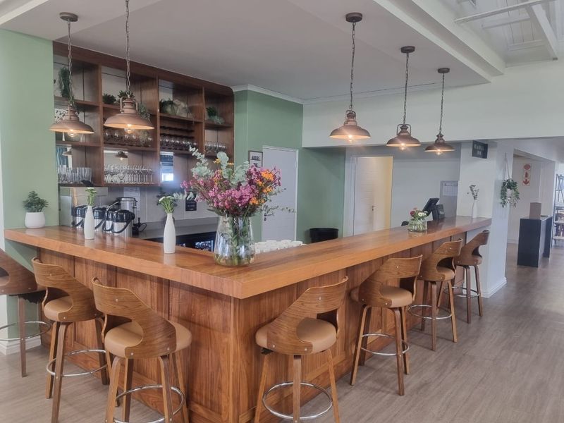 A well-maintained communal bar area featuring a custom timber counter, integrated shelving, and stylish pendant lighting, perfect for social gatherings within the retirement village.