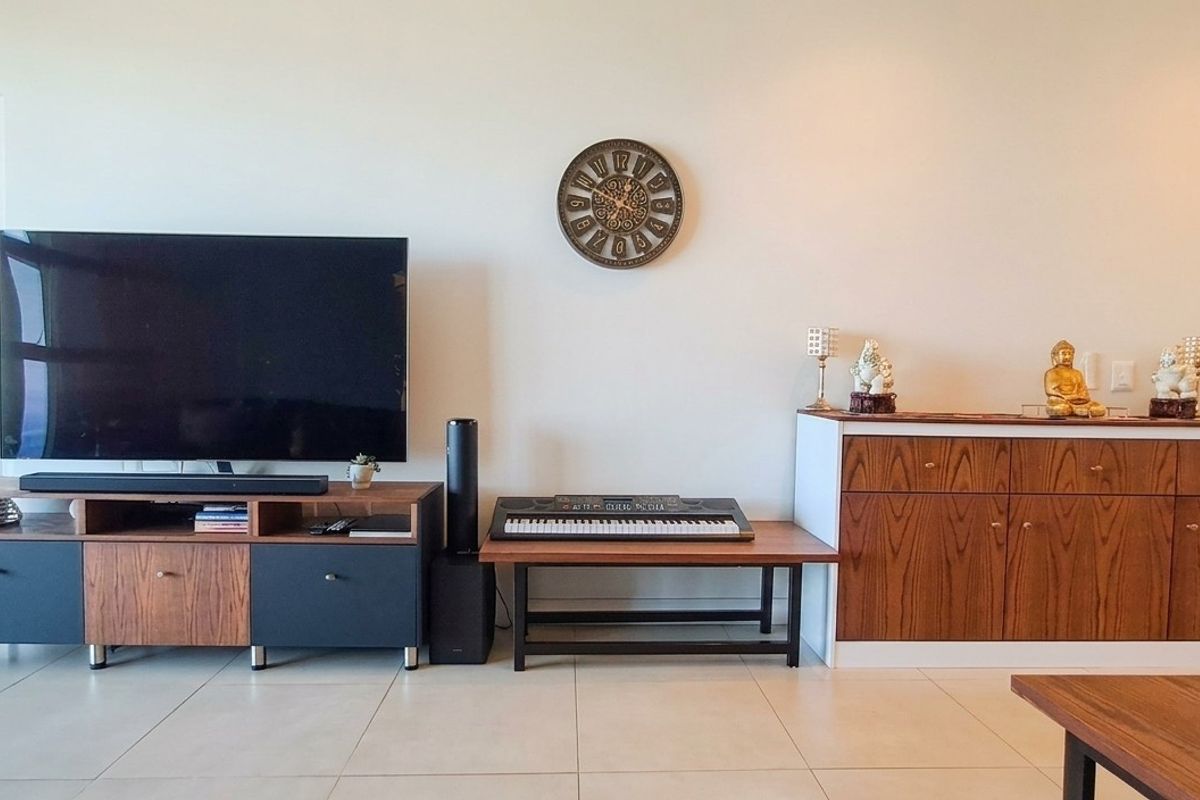 A well-maintained living area featuring neutral tiled flooring, modern built-in cabinetry, and recessed ceiling lighting, creating a clean and functional space.