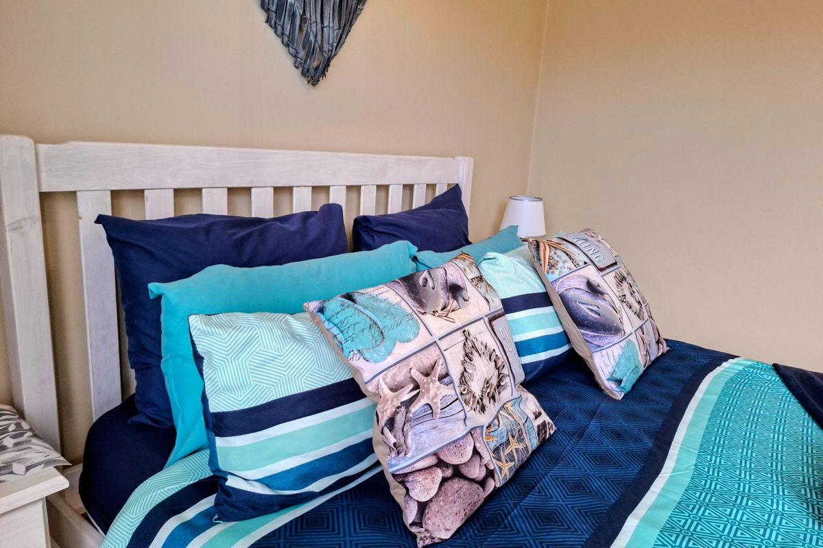 A bedroom interior featuring a wooden headboard and neutral wall paint.