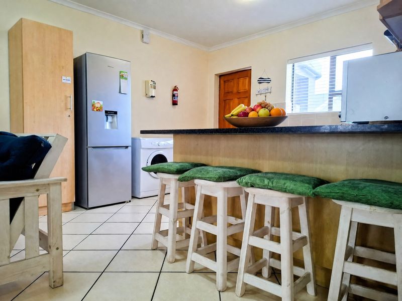 A functional kitchen area featuring a breakfast bar with granite countertops, tiled flooring, and built-in cabinetry, providing a practical space for daily use.