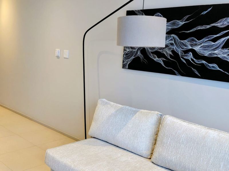 A well-maintained living area featuring neutral tiled flooring and modern recessed lighting, providing a clean and contemporary aesthetic.