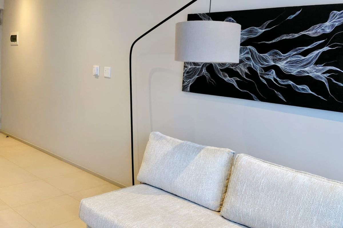 A well-maintained living area featuring neutral tiled flooring and modern recessed lighting, providing a clean and contemporary aesthetic.