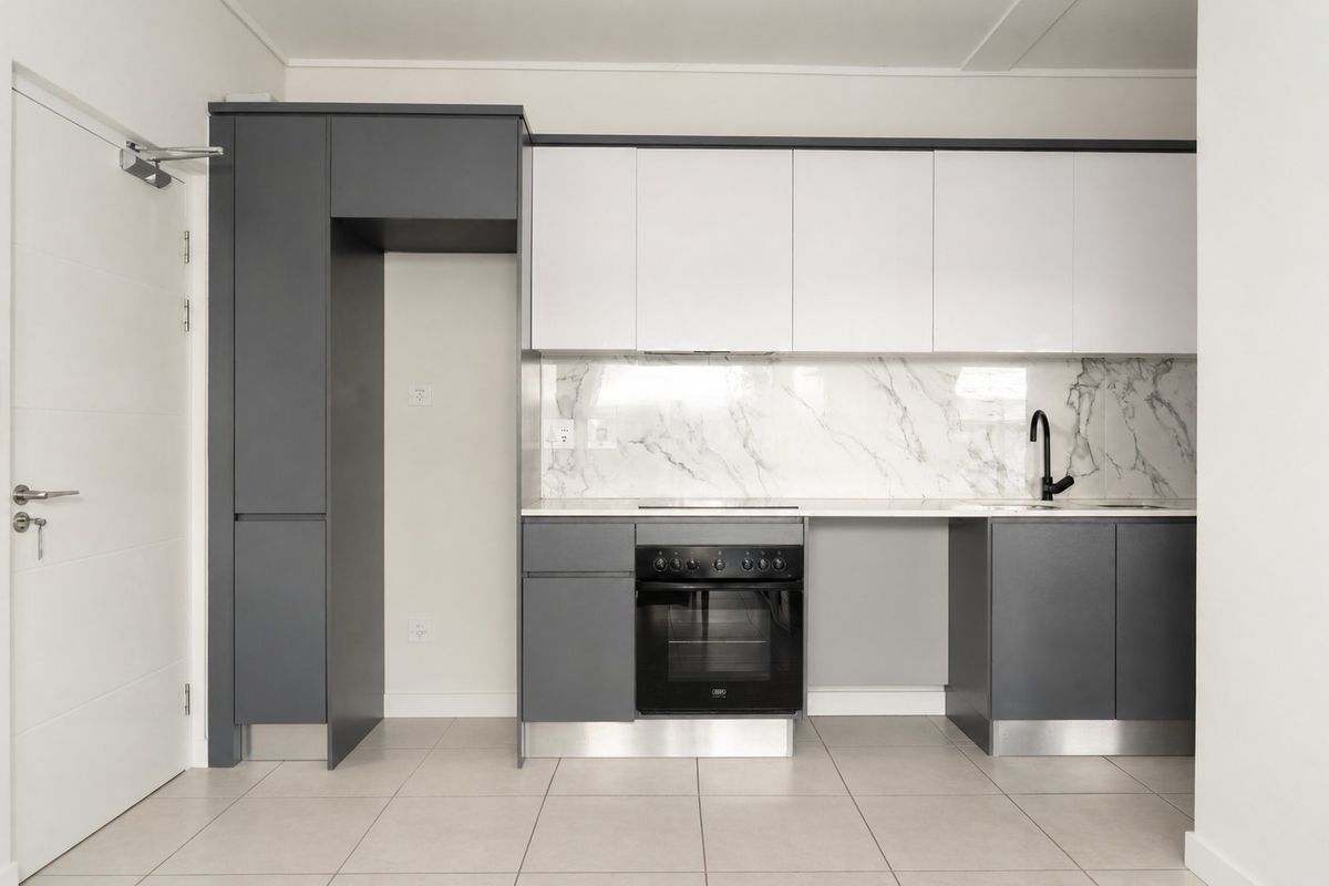 Modern kitchen featuring two-tone cabinetry, marble-look splashback, built-in oven, cooktop, and neutral tiled flooring in a clean, contemporary layout.