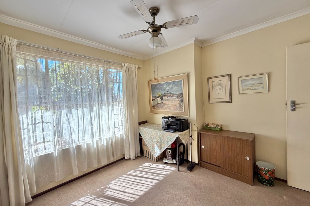 A bedroom featuring carpeted flooring, a ceiling fan, and coved cornicing, offering a functional space with natural light.
