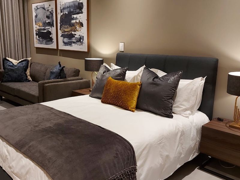 A well-appointed bedroom featuring neutral wall tones, integrated lighting, and a spacious layout suitable for a comfortable living environment.