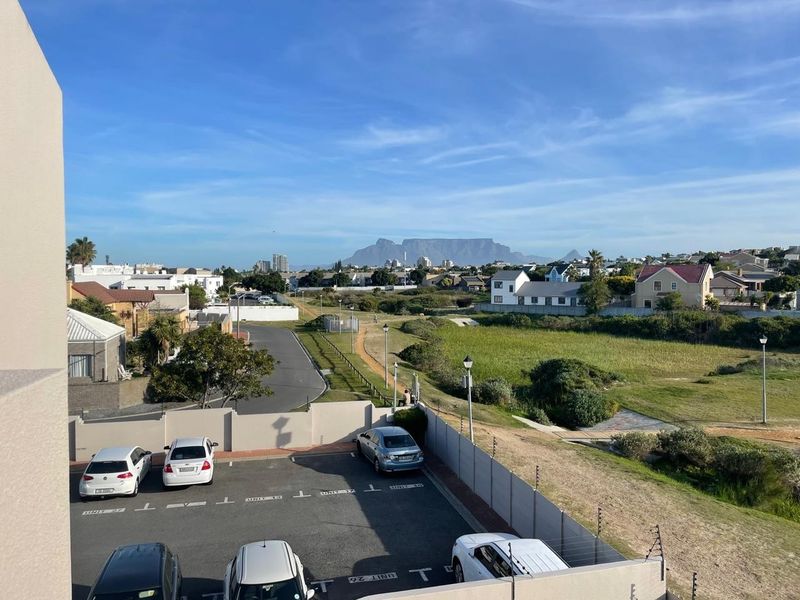 Elevated view overlooking the parking area and surrounding neighborhood with a clear perspective of Table Mountain in the distance.