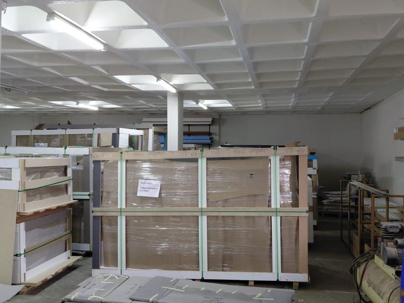 A functional industrial utility or storage space featuring a waffle slab ceiling, concrete flooring, and overhead fluorescent lighting.