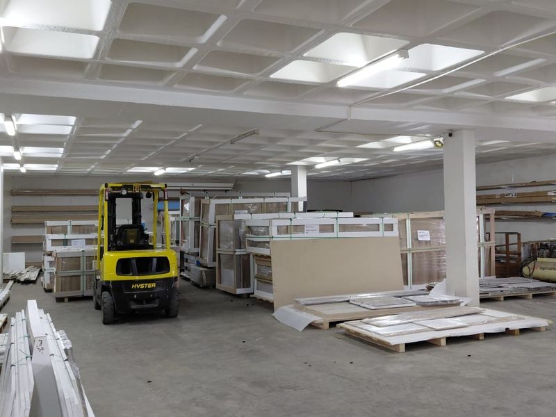 Spacious industrial warehouse area featuring a waffle slab ceiling, concrete flooring, and structural support columns, currently utilized for storage and logistics.