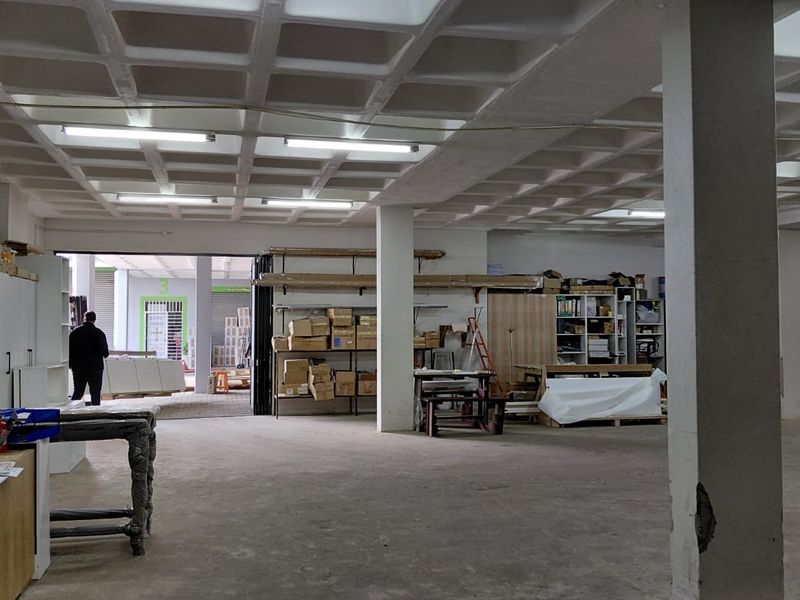 Spacious industrial utility area featuring a waffle slab ceiling, concrete flooring, and structural columns, suitable for storage or workshop operations.
