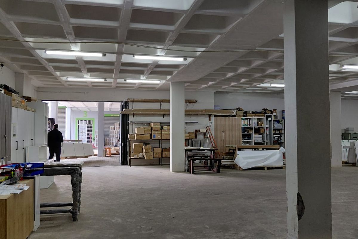 Spacious industrial utility area featuring a waffle slab ceiling, concrete flooring, and structural columns, suitable for storage or workshop operations.