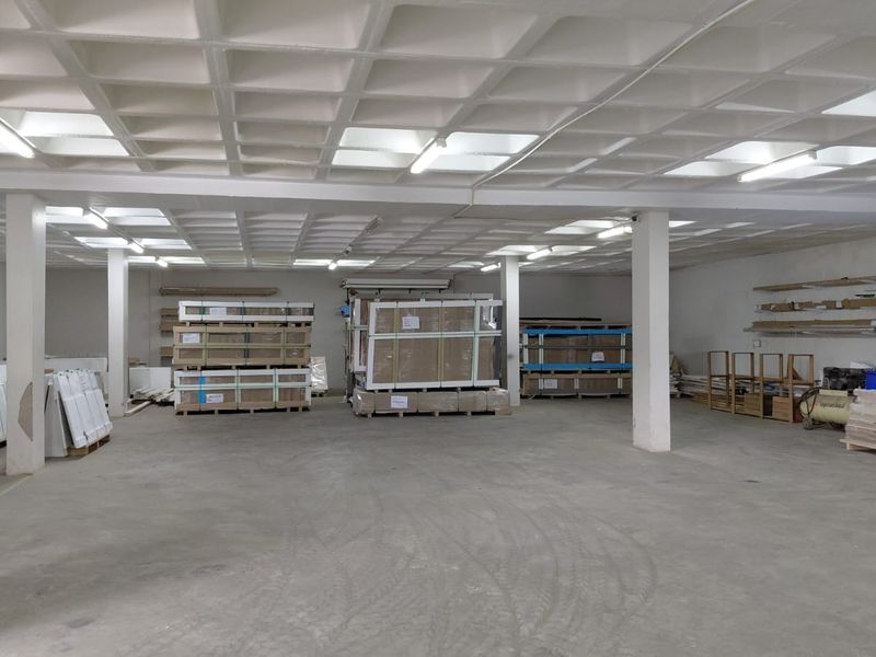 Spacious industrial utility or warehouse area featuring a waffle slab ceiling, concrete flooring, and structural support columns, suitable for storage or light industrial operations.