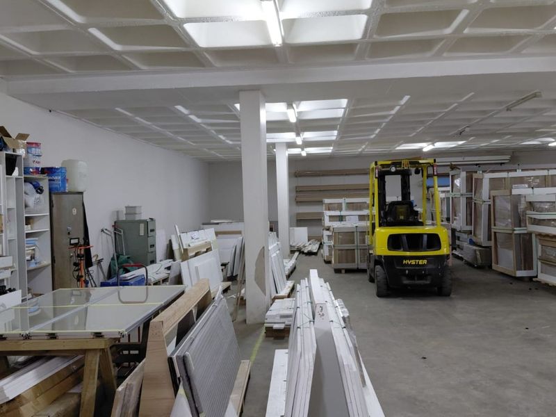 Spacious industrial warehouse area featuring a waffle slab ceiling, concrete flooring, and structural support columns, suitable for storage or light manufacturing operations.