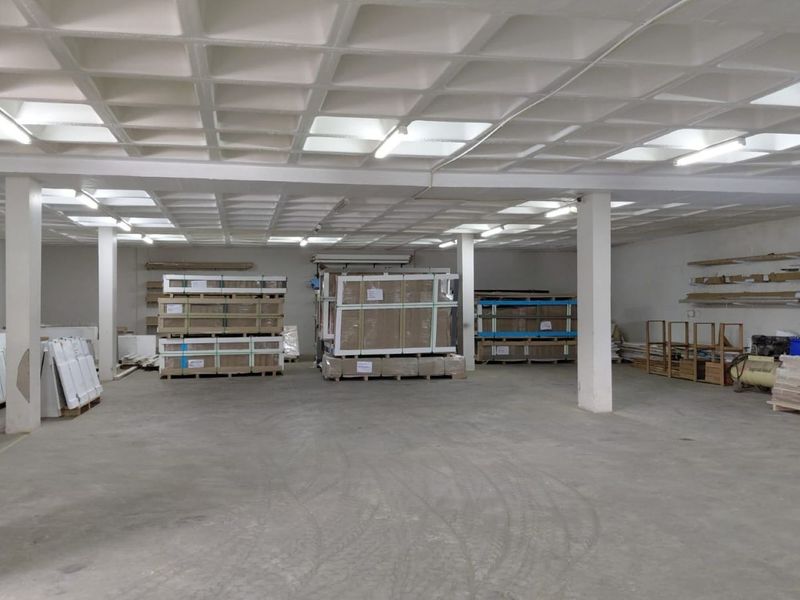 Spacious industrial utility area featuring a waffle slab ceiling, concrete flooring, and structural support columns, suitable for storage or workshop use.