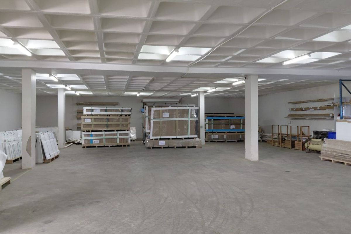 Spacious industrial utility area featuring a waffle slab ceiling, concrete flooring, and structural support columns, suitable for storage or workshop use.