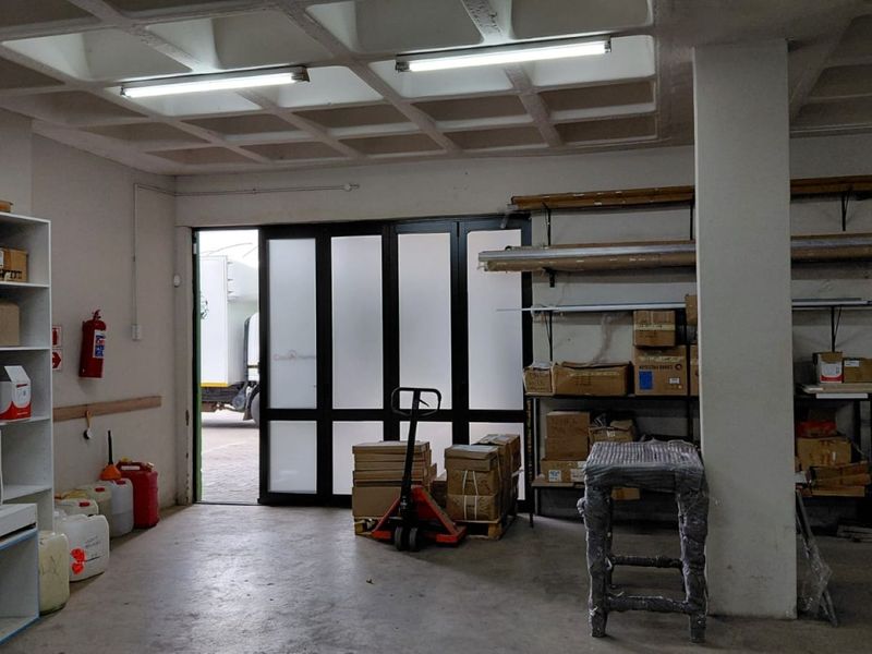Industrial utility space featuring a waffle slab ceiling, concrete flooring, and a large sliding glass door providing access to the exterior.