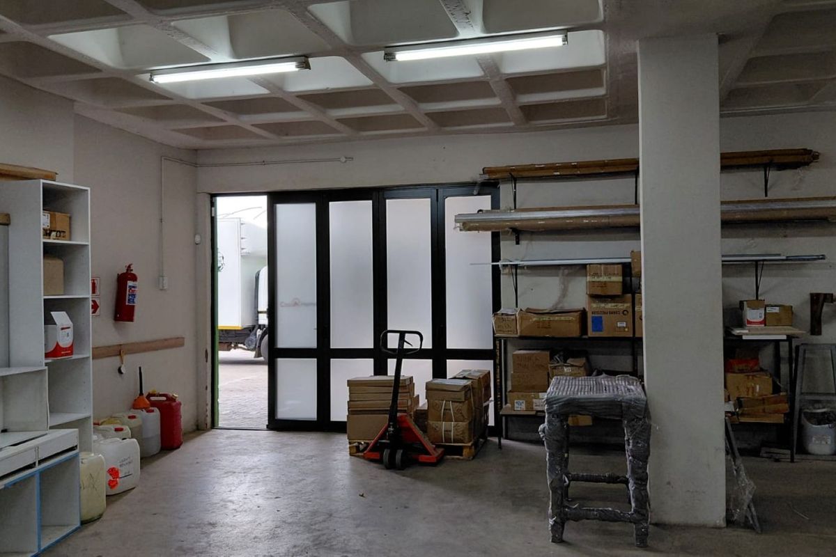 Industrial utility space featuring a waffle slab ceiling, concrete flooring, and a large sliding glass door providing access to the exterior.