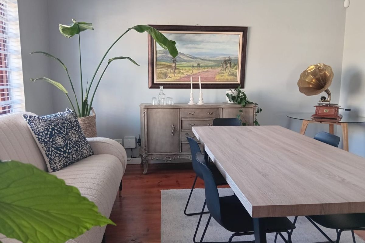 A well-maintained living area featuring warm timber flooring and venetian blinds, providing a comfortable and inviting space.