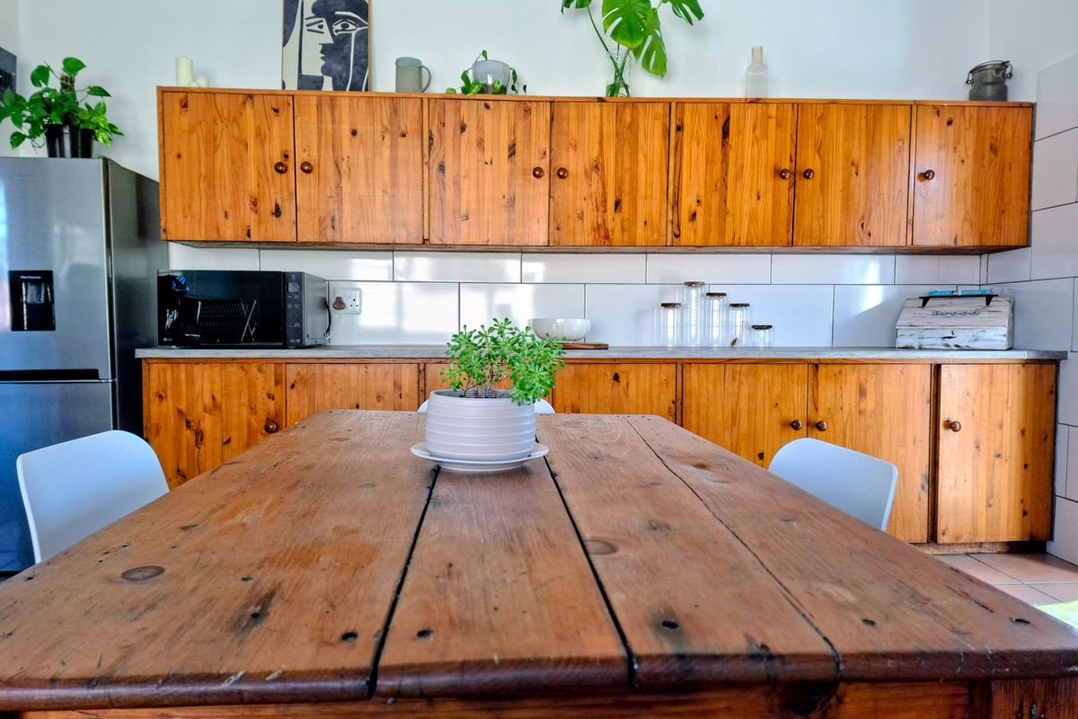 A kitchen featuring traditional wooden cabinetry, a clean tiled backsplash, and ample counter space, offering a functional and classic aesthetic.