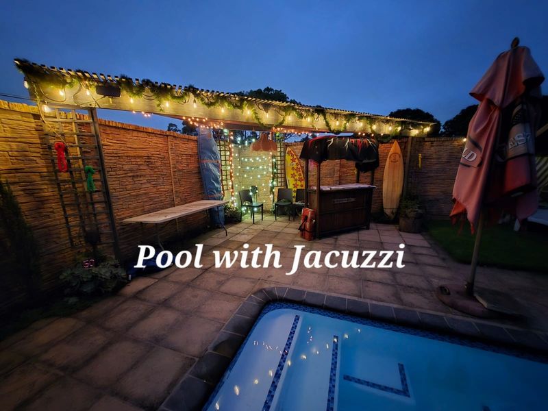 Outdoor pool area featuring a paved patio, timber pergola, and brick boundary wall, perfect for evening relaxation and entertainment.