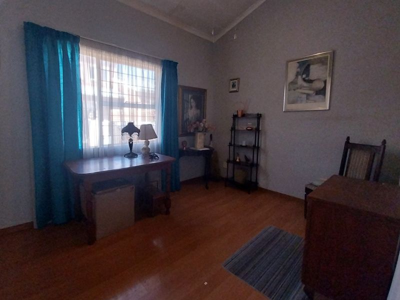 A bedroom featuring laminate flooring and a coved ceiling, providing a functional space with natural light.