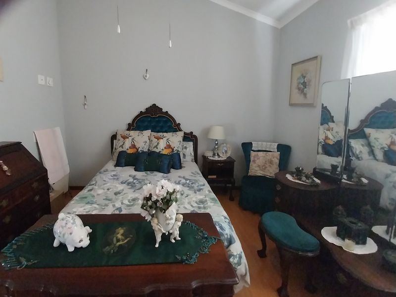 A bedroom featuring a vaulted ceiling and hardwood flooring, offering a comfortable and traditional living space within the retirement village.