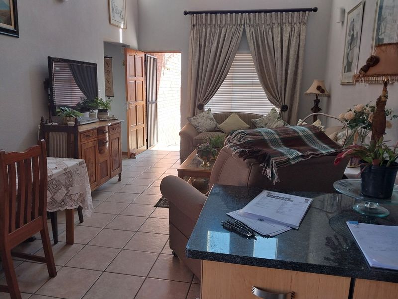 Open plan living area featuring tiled flooring, granite kitchen counter, and direct access to an exterior entrance.