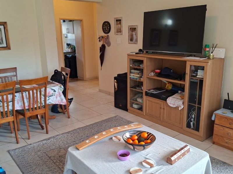 Open plan living and dining area with tiled flooring, providing a functional layout with direct access to the kitchen area.