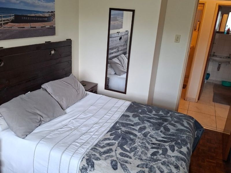 A bedroom featuring parquet flooring and direct access to an en-suite bathroom.