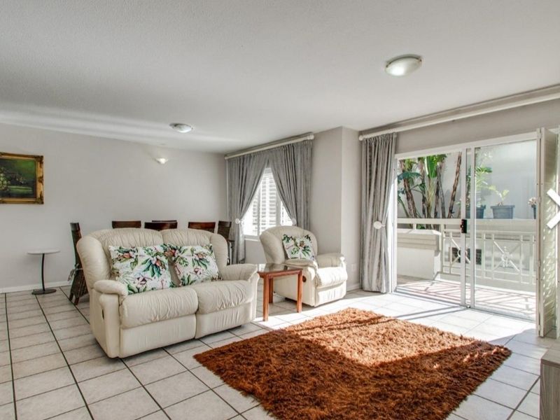 Open plan living and dining area featuring tiled flooring and large sliding glass doors providing access to an outdoor balcony.