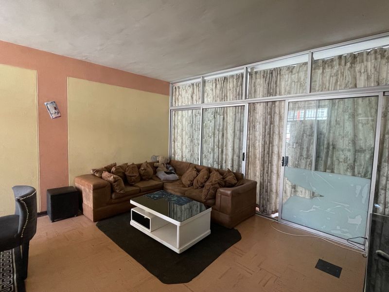 Living room featuring parquet flooring and large sliding glass doors with aluminum frames, providing access to an outdoor area.