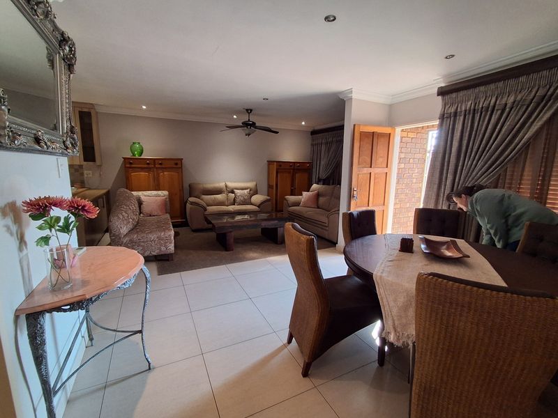 Spacious open-plan living and dining area featuring tiled floors, recessed lighting, and direct access to an outdoor patio space.