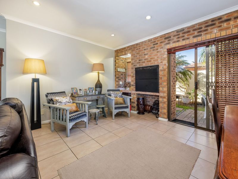 Spacious living area featuring an exposed brick wall, built-in fireplace, and sliding glass doors providing direct access to the outdoor patio area.