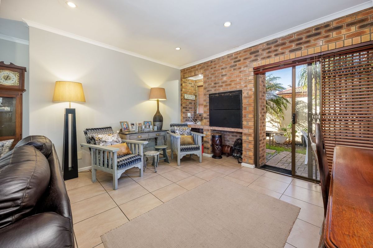 Spacious living area featuring an exposed brick wall, built-in fireplace, and sliding glass doors providing direct access to the outdoor patio area.