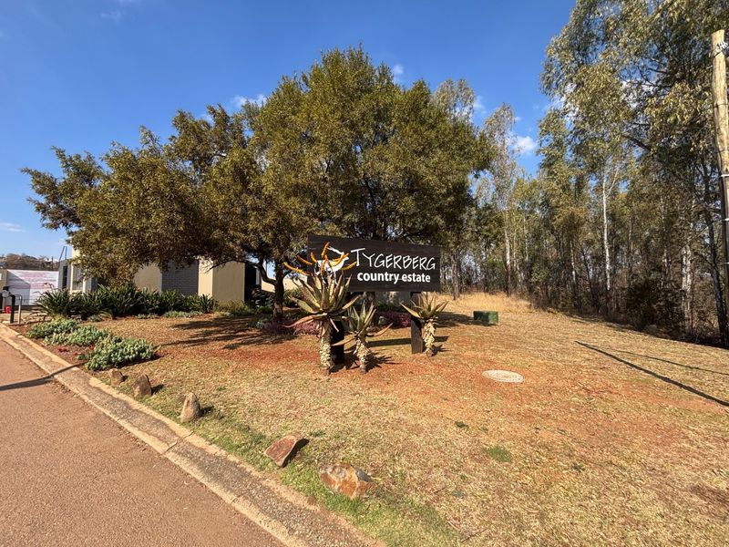 Entrance view of Tygerberg Country Estate featuring established trees, landscaped garden beds, and clear estate signage.