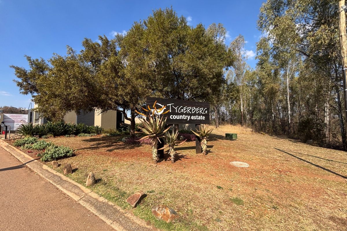 Entrance view of Tygerberg Country Estate featuring established trees, landscaped garden beds, and clear estate signage.