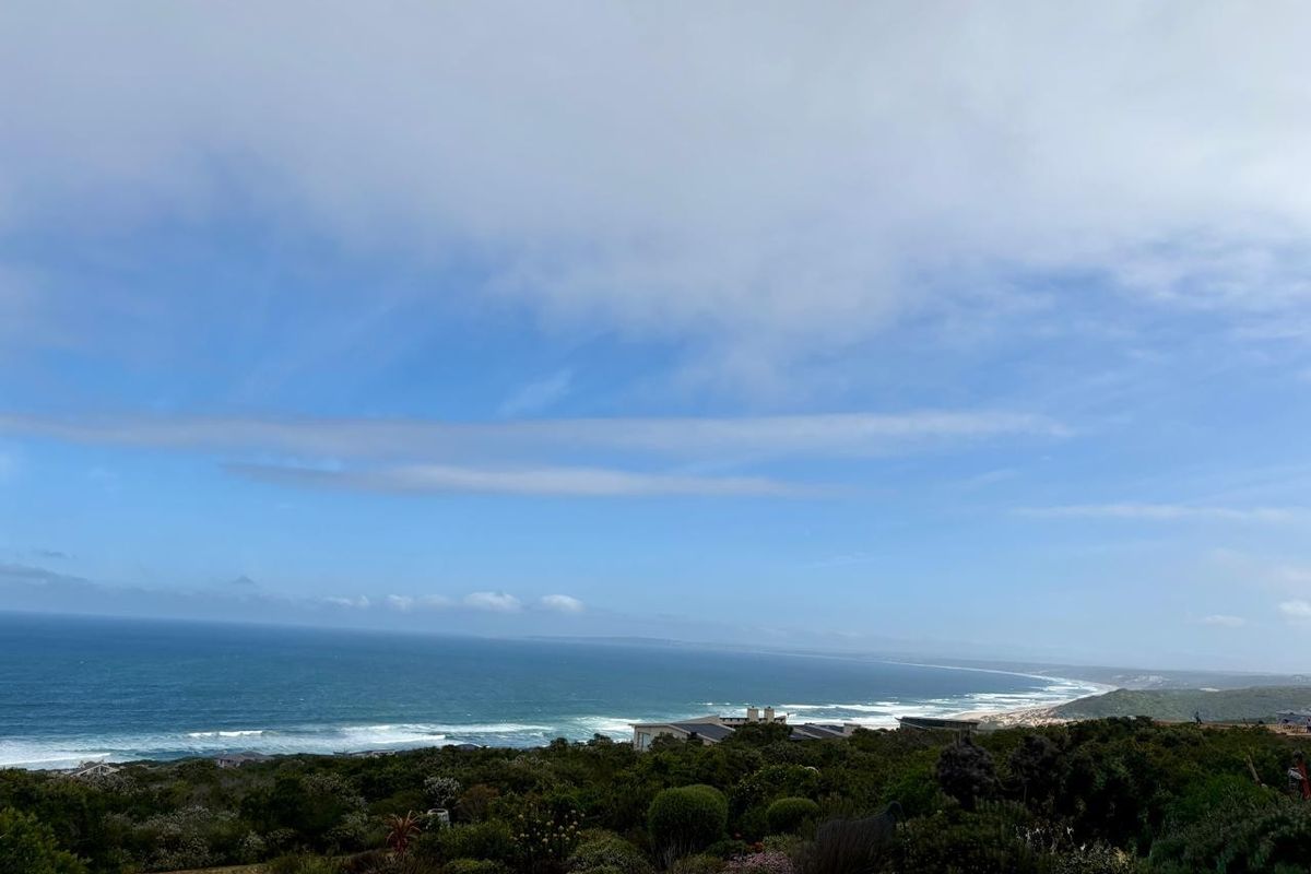 A scenic elevated view overlooking the coastline, ocean, and surrounding natural vegetation.