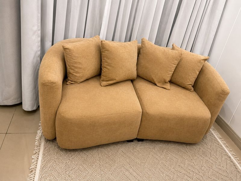 A cozy living area featuring neutral curtains and tiled flooring, providing a comfortable and well-maintained space.