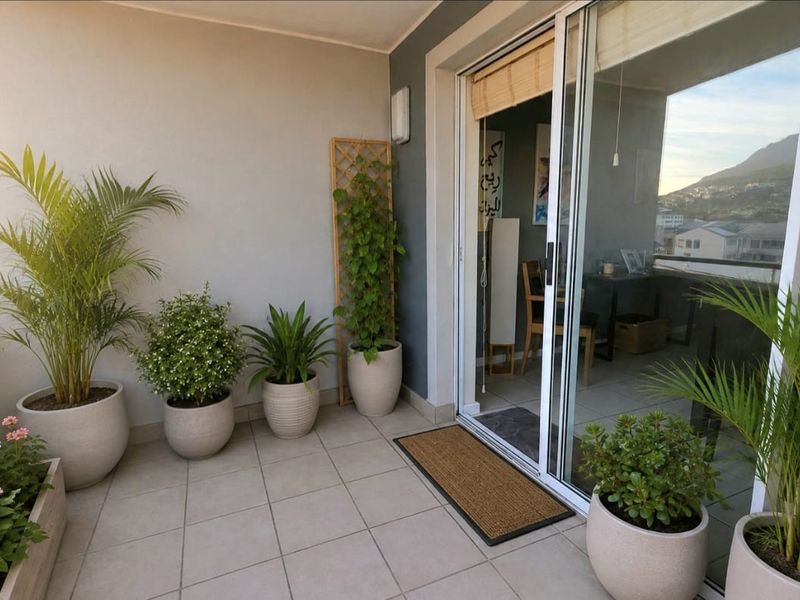 A well-maintained balcony featuring tiled flooring, a sliding glass door entrance, and a secure balustrade with pleasant outdoor views.