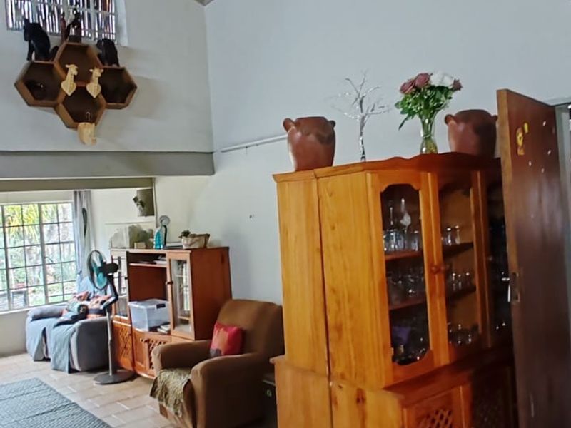 Spacious living area featuring a high vaulted timber ceiling and ceramic tiled flooring, offering a warm and rustic atmosphere.